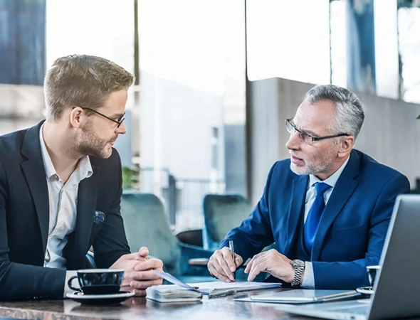 Business coach in a suit discussing strategy with a client during a consultation in Minneapolis, MN.