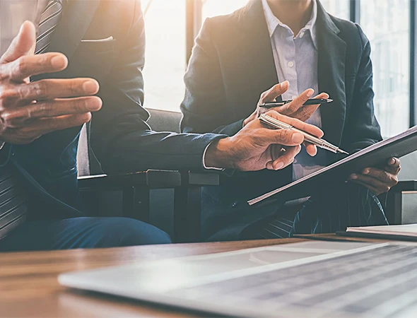 Business coaches in a strategy meeting analyzing growth metrics and identifying blind spots to provide strategic direction for performance improvement.