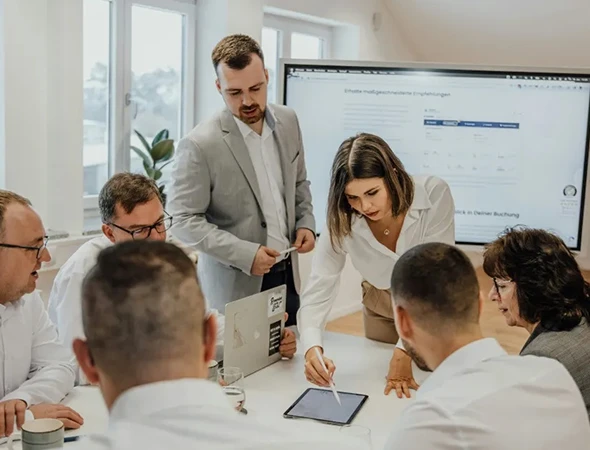 A professional team in Omaha, NE, collaborating around a tablet and digital screen for a cash flow management and financial planning session.