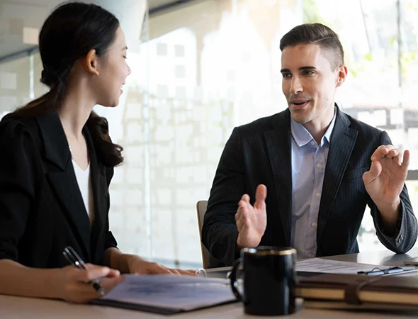 A leadership development consultant in Des Moines, IA, conducting a one-on-one mentoring session with a business professional to improve management styles.