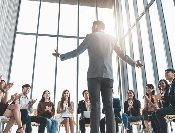 Local business growth coach in Des Moines, IA, presenting scaling strategies to a large group of small business owners.