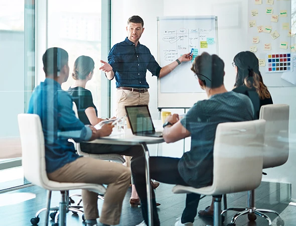 Small business coaching session in Columbus with a group of entrepreneurs discussing growth plans in a modern office.