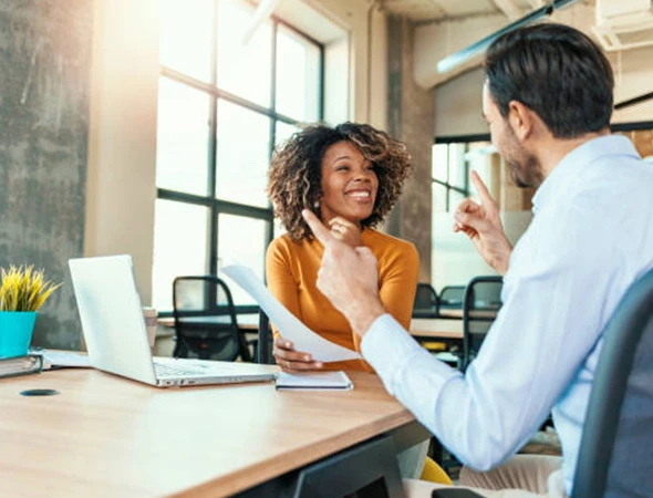 A female executive smiling while receiving personalized business coaching and strategic guidance in Des Moines, Iowa.