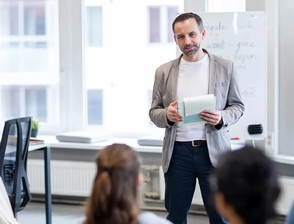 An expert accountability coach holding a notebook while providing consistency coaching and follow-through support in Milwaukee.